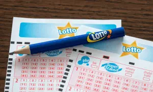Uszkodzony kupon lotto z pralki. Czy da się odzyskać wygraną? Niebieski ołówek leży na kuponach.