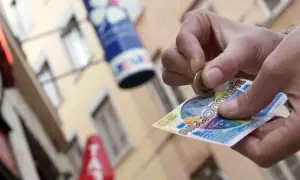 Ręka zdrapuje zdrapkę "Millionaire", krok po kroku po pieniądze. Czy to będzie wygrana pierwszego stopnia?