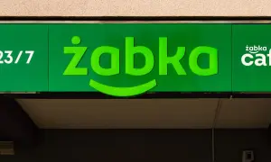 Zielony neon sklepu Żabka z napisem "23/7" i logo "żabka cafe".
