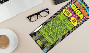 Zdrapka Giga Cash z szansą na milion złotych leży obok okularów i kawy.