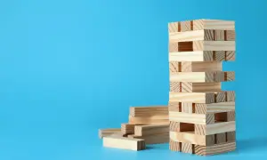 Wieża z klocków Jenga, obok stos luźnych elementów. Zagadki i prawa fizyki w grze, jak wygrywać w jengę bez przewracania.