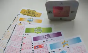 Zegar pokazuje 3:18, a obok leżą kupony gier liczbowych: Eurojackpot, Mini Lotto, Ekstra Pensja, Multi Multi i Lotto. Sprawdź, do której godziny można wysłać lotto w kolekturze.