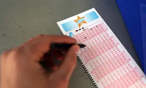 Ręka z długopisem zaznacza liczby na kuponie Duży Lotek. Dowiedz się, jak wypełnić kupon lotto duży lotek i spróbuj szczęścia!