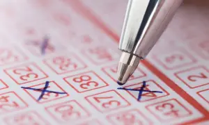 Długopis zaznacza liczby na kuponie lotto. Czy wygraną ze zdrapki można wypłacić prosto na konto bankowe?