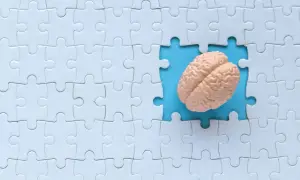 Model mózgu w wyciętym fragmencie białej układanki. Czy rozwiązywanie krzyżówek naprawdę chroni przed chorobą Alzheimera?