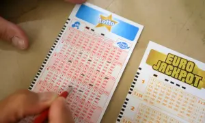 Ręka zaznacza liczby na kuponie Lotto. Dowiedz się, co zrobić po wygraniu szóstki w lotto krok po kroku.