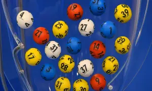 Kolorowe kulki z numerami wirują w błękitnej maszynie losującej. Czy to właśnie te gorące liczby w lotto przyniosą komuś szczęście?