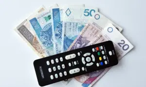 Pilot do telewizora leży na stosie banknotów. Czy trzeba płacić abonament żeby wygrać w RMF FM?