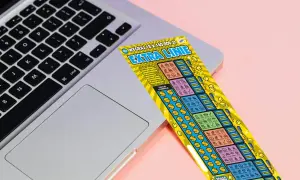 Zdrapka "Extra Linie" leży na laptopie. Czy uda się znaleźć wygrywające symbole i dodatkowe linie?