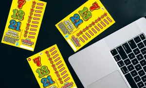 Żółte zdrapki Lotto leżą obok laptopa. Czy sprzedawca w kolekturze wie w której zdrapce jest wygrana?