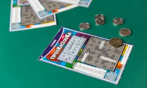 Zdrapek z krzyżówką i monetami na zielonym tle. Jak Totalizator Sportowy dba o bezpieczeństwo algorytmów drukowania zdrapek.