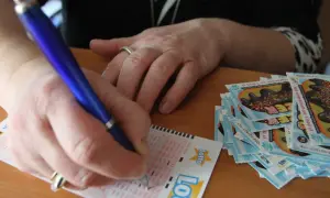 Ręka wypełnia kupon Lotto. Jak chronić swoją anonimowość po wygraniu milionów w krajowej loterii?