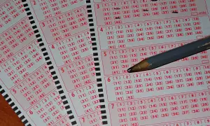 Kaskada kuponów lotto, gotowych do wypełnienia. Ołówek czeka, by zaznaczyć zwycięskie liczby. Wyniki sprawdź, gdy nadejdzie ten dzień!