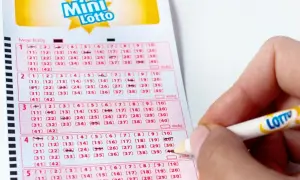 Ręka zaznacza liczby na kuponie Mini Lotto. To pokazuje, jak sprawdzana jest uczciwość bębna i certyfikaty maszyn losujących.