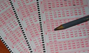 Kupony loterii Mega Millions i Powerball, jak legalnie zagrać z Polski. Ołówek zaznacza liczby.