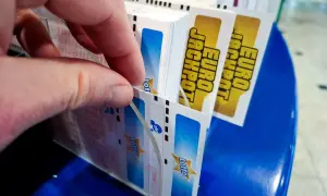 Dłoń wybiera kupony Lotto, marząc o multipasko wysokich wygranych.