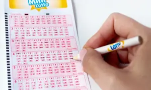 Ręka zaznacza liczby na kuponie Mini Lotto. Kto wie, może to właśnie te liczby przyniosą wygraną!