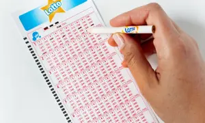 Ręka z ołówkiem zaznacza liczby na kuponie Lotto. Jak poprawnie wypełnić wniosek o loterię wizową DV do USA bez błędów?