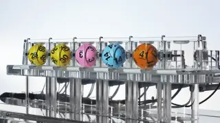 Kaskada Lotto: dlaczego zawsze losuje 12 liczb i jak sprawdzić wygraną? Kolorowe kule z numerami w maszynie losującej.