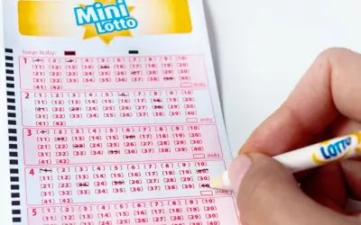 Ręka zaznacza liczby na kuponie Mini Lotto. To pokazuje, jak sprawdzana jest uczciwość bębna i certyfikaty maszyn losujących.
