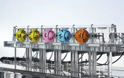 Kaskada Lotto: dlaczego zawsze losuje 12 liczb i jak sprawdzić wygraną? Kolorowe kule z numerami w maszynie losującej.