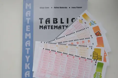 Matematyka w zdrapkach: jak obliczyć wartość oczekiwaną kuponu? Książka i kupony lotto na stole.
