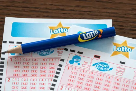 Uszkodzony kupon lotto z pralki. Czy da się odzyskać wygraną? Niebieski ołówek leży na kuponach.