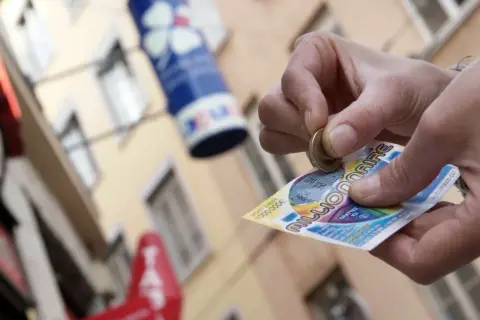 Ręka zdrapuje zdrapkę "Millionaire", krok po kroku po pieniądze. Czy to będzie wygrana pierwszego stopnia?