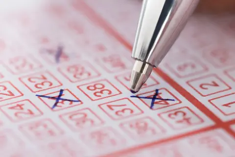 Długopis zaznacza liczby na kuponie lotto. Dowiedz się o podatek od wygranej powyżej 2280 zł lotto zasady potrącania w kolekturze.