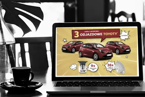 Na ekranie laptopa reklama loterii z samochodami Toyota. Czy loterie z samochodami w internecie są w pełni legalne w Polsce? Sprawdź!