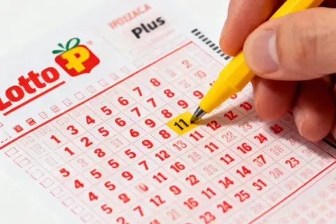 Ręka zaznacza numer 11 na kuponie Lotto Plus. Czy to będzie Twój szczęśliwy numer? mega lotto pl.