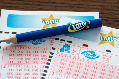 Ołówek na kuponach Lotto, gotowy do zaznaczenia najczęstszych liczb lotto.