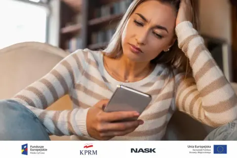 Zmartwiona kobieta czyta na telefonie o oszustwach na loterie i fałszywych wygranych. Jak rozpoznać takie wiadomości?