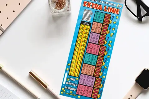 Zdrapka "Extra Linie" leży obok notatnika i okularów. Czy uda się zdrapać wygraną?