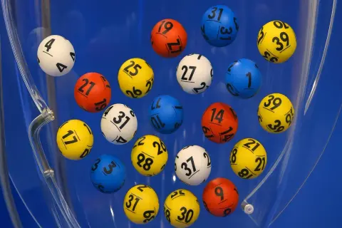 Kolorowe kulki z numerami wirują w błękitnej maszynie losującej. Czy to właśnie te gorące liczby w lotto przyniosą komuś szczęście?