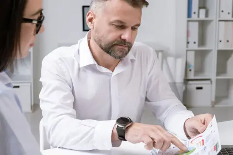Mężczyzna i kobieta analizują wykresy. Czy pracownicy firmy organizującej loterię mogą brać w niej udział?
