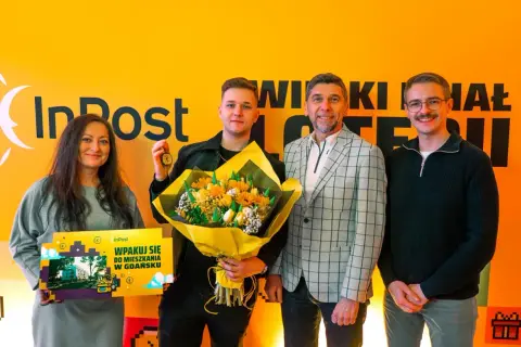 Szczęśliwiec, kto wygrał mieszkanie w loterii InPost, odbiera klucze i bukiet.
