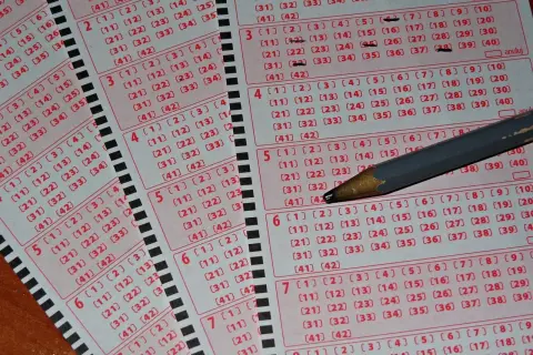 Kupony loterii Mega Millions i Powerball, jak legalnie zagrać z Polski. Ołówek zaznacza liczby.