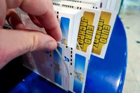 Dłoń wybiera kupony Lotto, marząc o multipasko wysokich wygranych.