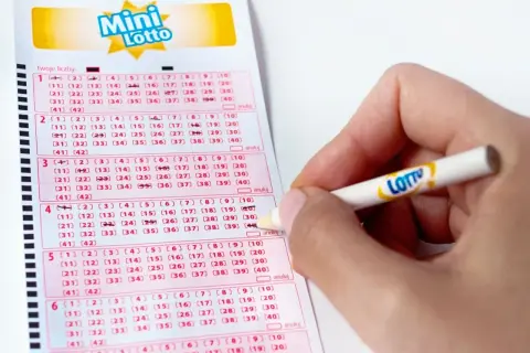 Ręka zaznacza liczby na kuponie Mini Lotto. Kto wie, może to właśnie te liczby przyniosą wygraną!