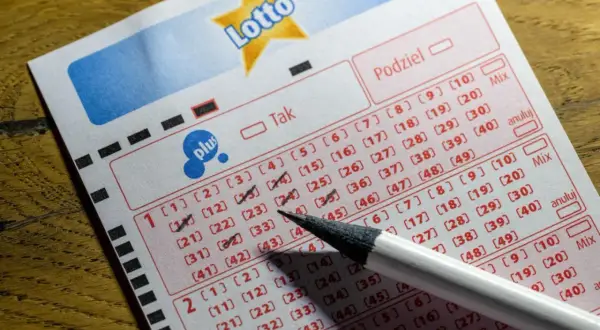 Kupon Lotto z zaznaczonymi liczbami i ołówkiem. Opłata manipulacyjna i dopłata w Lotto – na co idą pieniądze graczy?