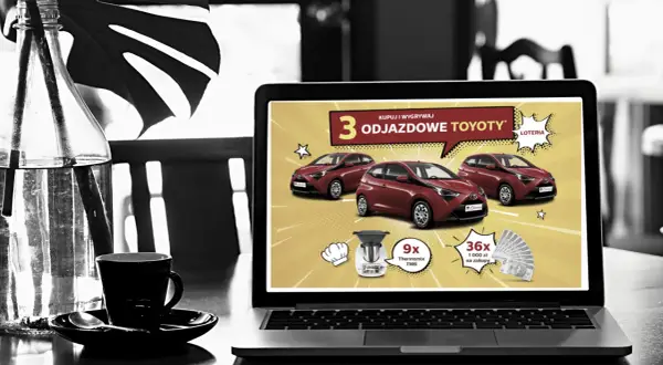 Na ekranie laptopa reklama loterii z samochodami Toyota. Czy loterie z samochodami w internecie są w pełni legalne w Polsce? Sprawdź!