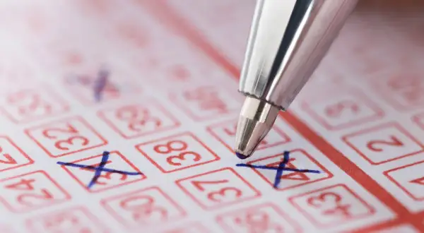 Długopis zaznacza liczby na kuponie lotto. Czy wygraną ze zdrapki można wypłacić prosto na konto bankowe?