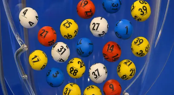 Kolorowe kulki z numerami wirują w błękitnej maszynie losującej. Czy to właśnie te gorące liczby w lotto przyniosą komuś szczęście?
