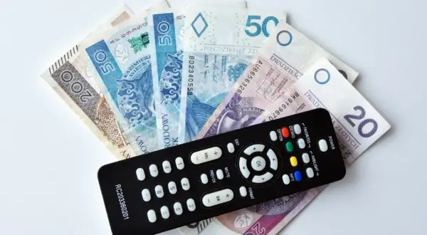 Pilot do telewizora leży na stosie banknotów. Czy trzeba płacić abonament żeby wygrać w RMF FM?