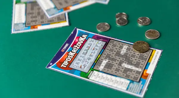 Zdrapek z krzyżówką i monetami na zielonym tle. Jak Totalizator Sportowy dba o bezpieczeństwo algorytmów drukowania zdrapek.