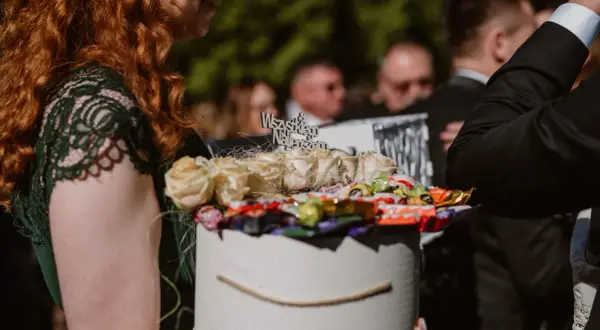 Oryginalny pomysł na prezent ślubny: pudełko z różami i słodyczami, zamiast kwiatów. Idealne, gdy zastanawiasz się, jakie zdrapki kupować na ślub zamiast kwiatów dla nowożeńców.