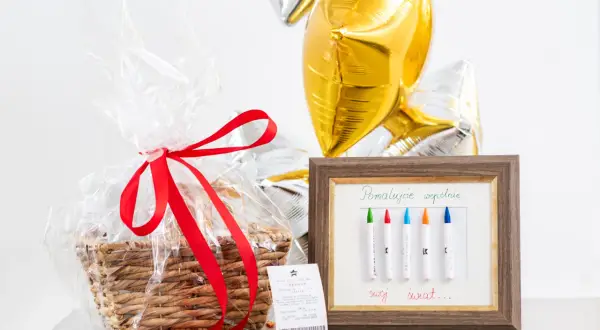 Prezent na ślub: kosz z upominkami, balony i ramka z kredkami do malowania wspólnego świata. Idealny pomysł, jak zapakować kupony lotto na ślub, by stworzyć niezapomnianą pamiątkę.