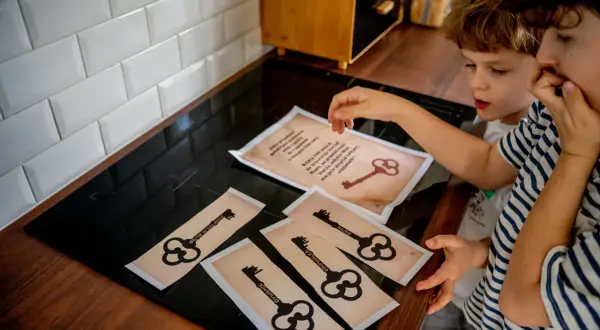 Dzieci rozwiązują zagadki, by stworzyć własny escape room w domu dla nastolatków. Klucze wskazują miejsca ukrycia wskazówek.