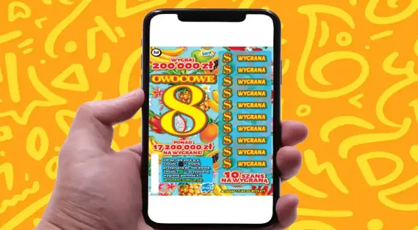 Ręka trzyma smartfon z grą "Owocowa eksplozja zdrapka". Na ekranie widać tropikalne owoce i symbol ósemki.